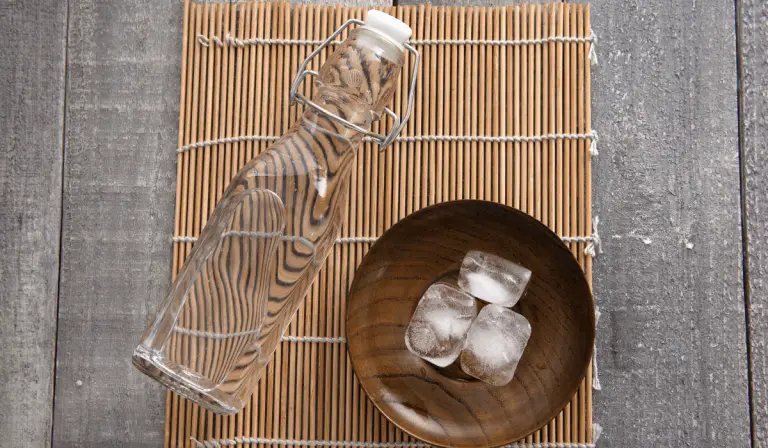 A wooden bowl filled with ice cubes, used for an ice ritual recipe.