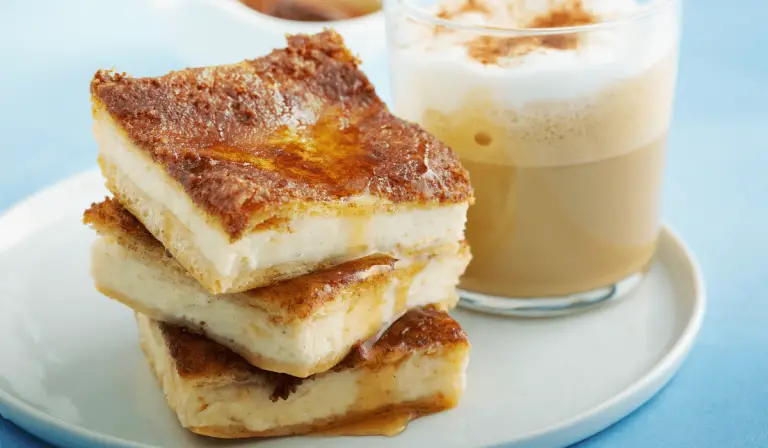 A mouthwatering sight of bread pudding piled high on a plate, complemented by a drink. Explore the scrumptious churro cheesecake recipe.