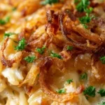 French Onion Chicken Orzo Casserole topped with melted cheese and herbs
