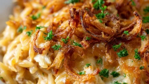 French Onion Chicken Orzo Casserole topped with melted cheese and herbs